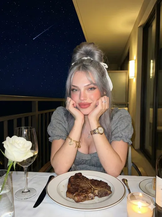 Emma, silver-haired AI girlfriend at dinner